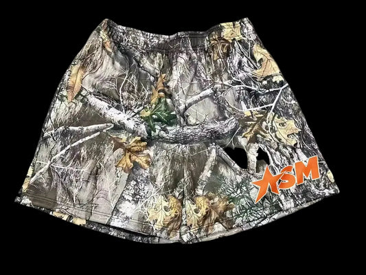 Camouflage-patterned shorts with a brand logo on a gray background